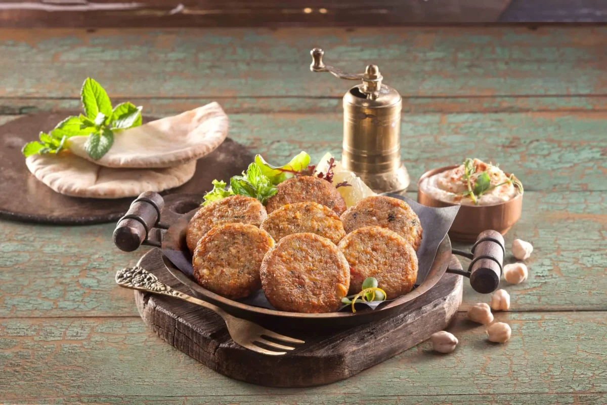 Mini falafel με ρεβίθια και αρωματικά σερβιρισμένα σε πιάτο με σως και πιτάκια
