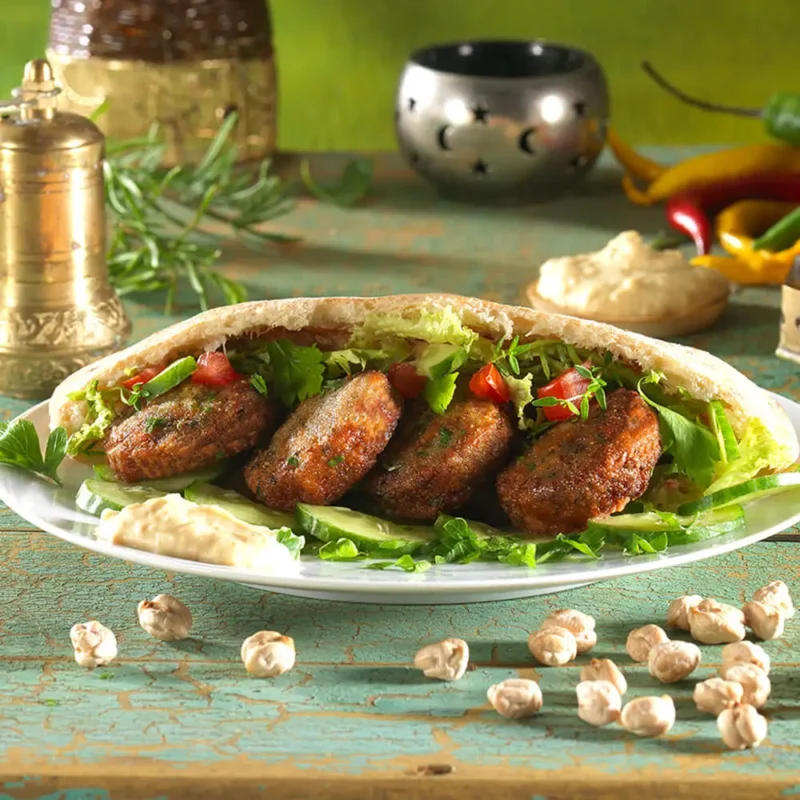 Ψημένα falafel με ρεβίθια και αρωματικά σερβιρισμένα σε πίτα σαν σάντουιτς σε ανατολίτικο τραπέζι