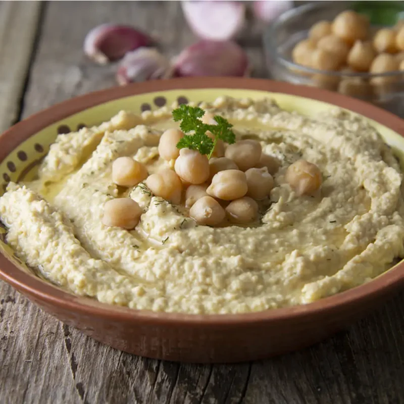 Χούμους σε πιάτο με διακόσμηση από ρεβίθια για συνοδευτικό plant-based πιάτο